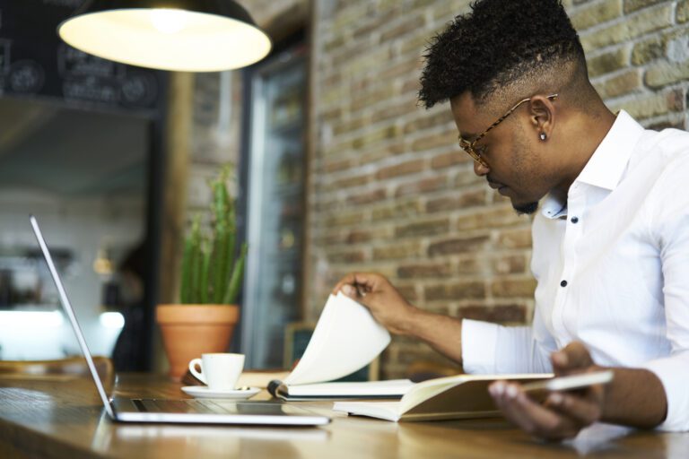 Investor Considers Papers At A Cafe.jpg